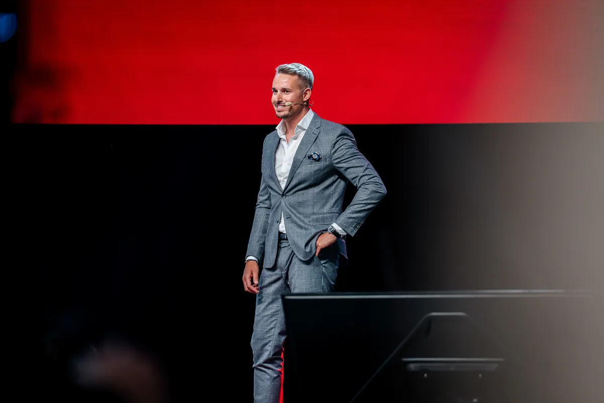 Řečník na nasvíceném pódiu firemní konference